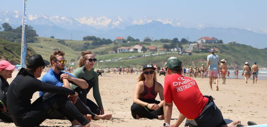 Surfkurs am Playa de Gerra mit den schneebedeckten Bergen im Hintergrund