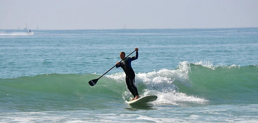 Stand Up Paddling im Meer mit Wellen