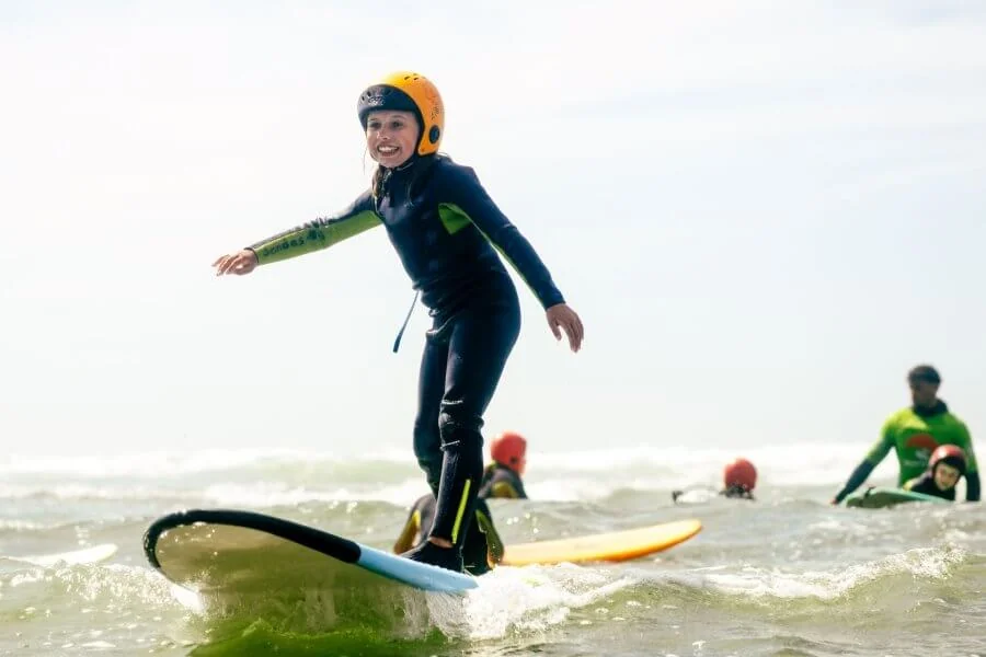 Kind mit Helm im Surfkurs von Tres Ondas in Ericeira Portugal
