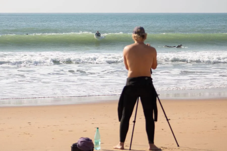 A-Frame Surfcoach Linus filmt Kursteilnehmerin Mariella beim Takeoff am Surfspot El Palmar Andalusien