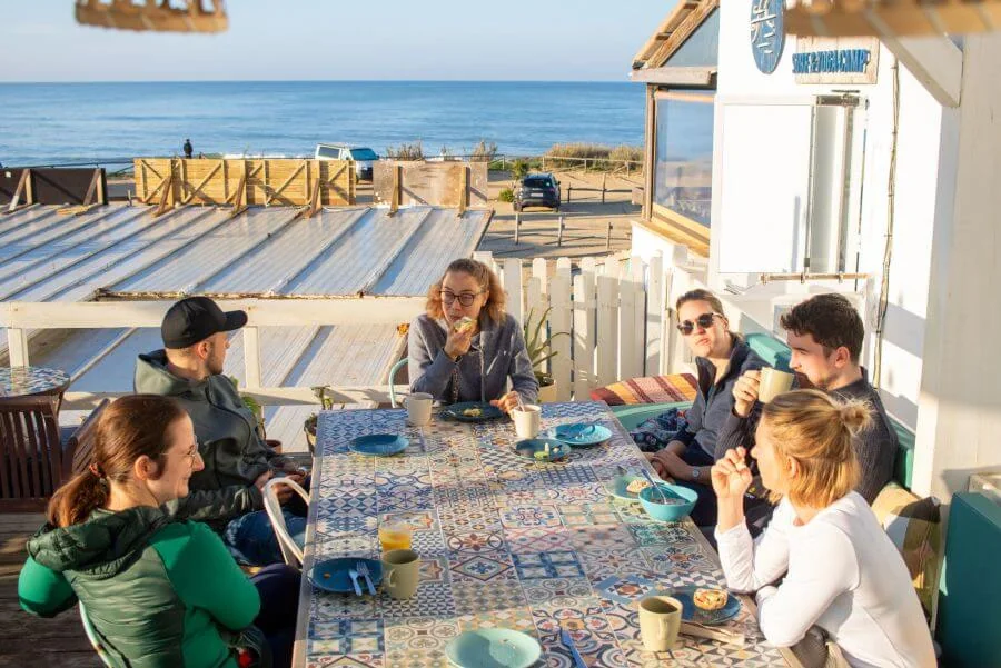 Gemeinsames Frühstück mit Meerblick auf der Sonnenterrasse im A-Frame Surfcamp Andalusien