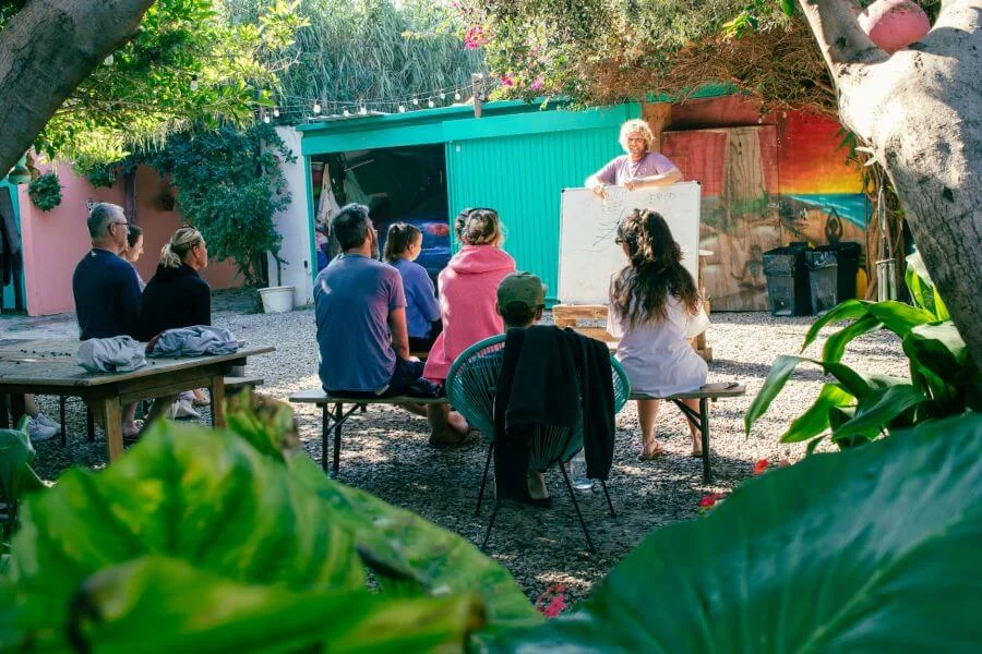 Surf-Theorie im sonnigen Innenhof vom A-Frame Surfcamp Andalusien