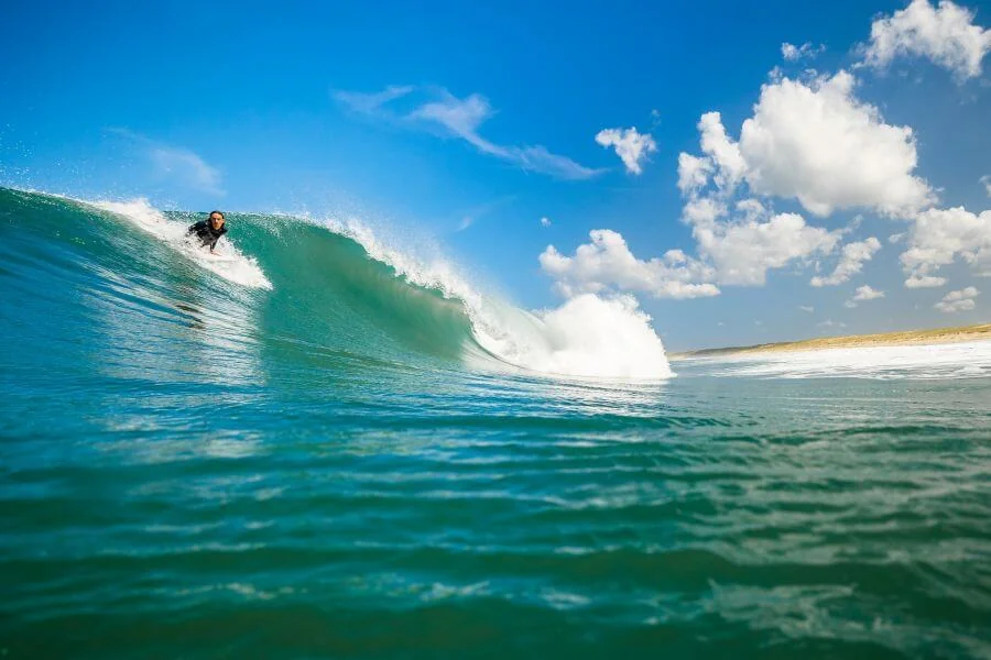 Surfer auf Welle - Wer in Frankreich surfen will, kann sich auf perfekte Wellen freuen