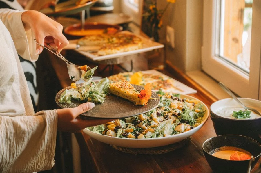 Ein Gast im Surf Spirit Portugal serviert sich das Mittagessen