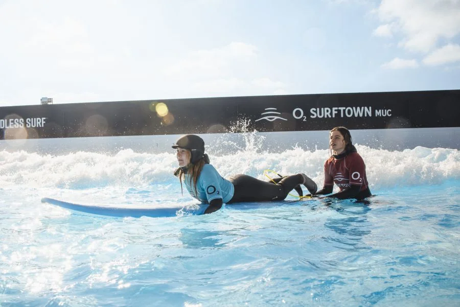 Surf-Anfängerin und Surflehrer im Surfkurs der O2 Surtown München