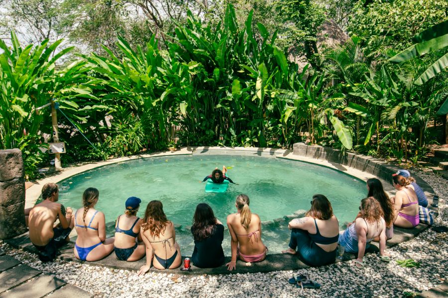 Dreamsea Surflehrer Jonny mit Surfboard im Pool