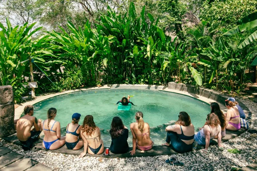 Dreamsea Surflehrer Jonny mit Surfboard im Pool