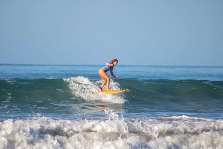 Dreamsea Surfkurs Teilnehmerin Catarina surft eine schöne grüne Welle im Intermediate Surfkurs am Playa Hermosa