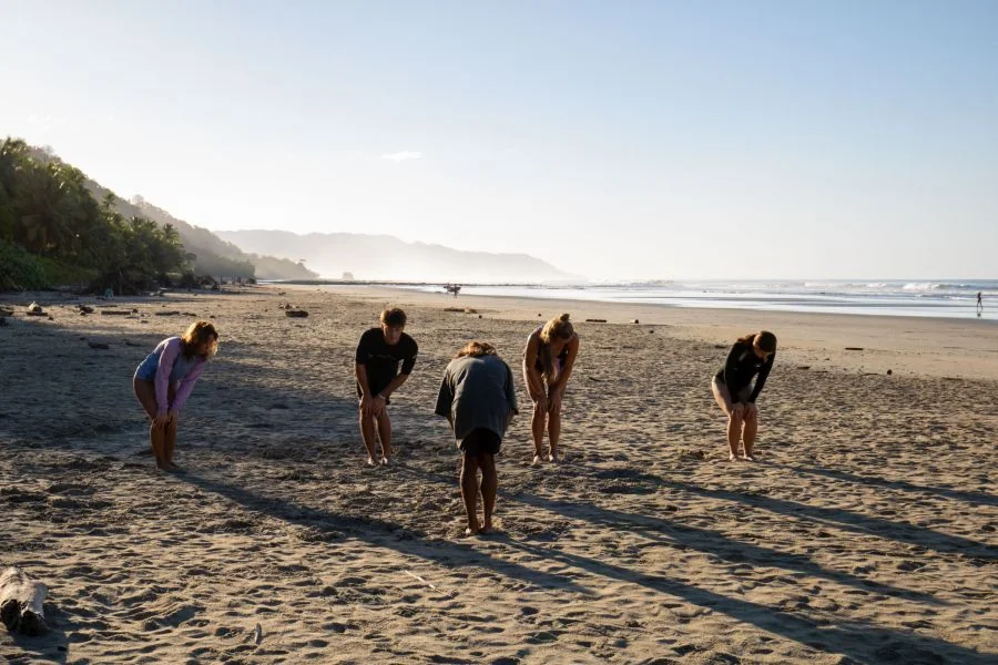 Gemeinsames Aufwärmen im Dreamsea Surfkurs mit Surflehrer Jefferson am Playa Hermosa bei Santa Teresa
