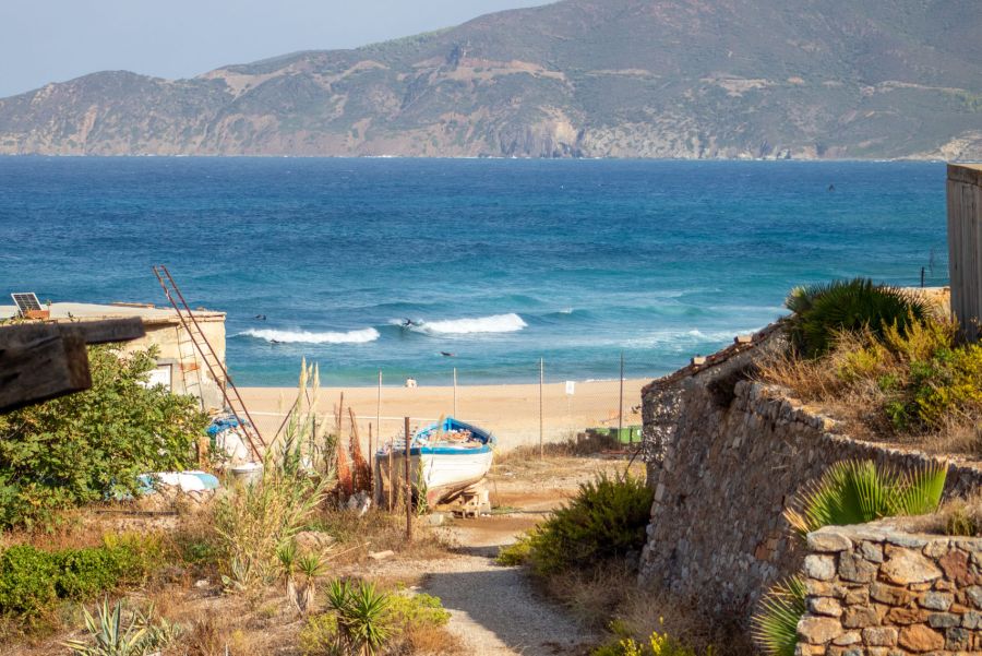 Surfer neben der Hafenmole von Buggerru im Südwesten von Sardinien