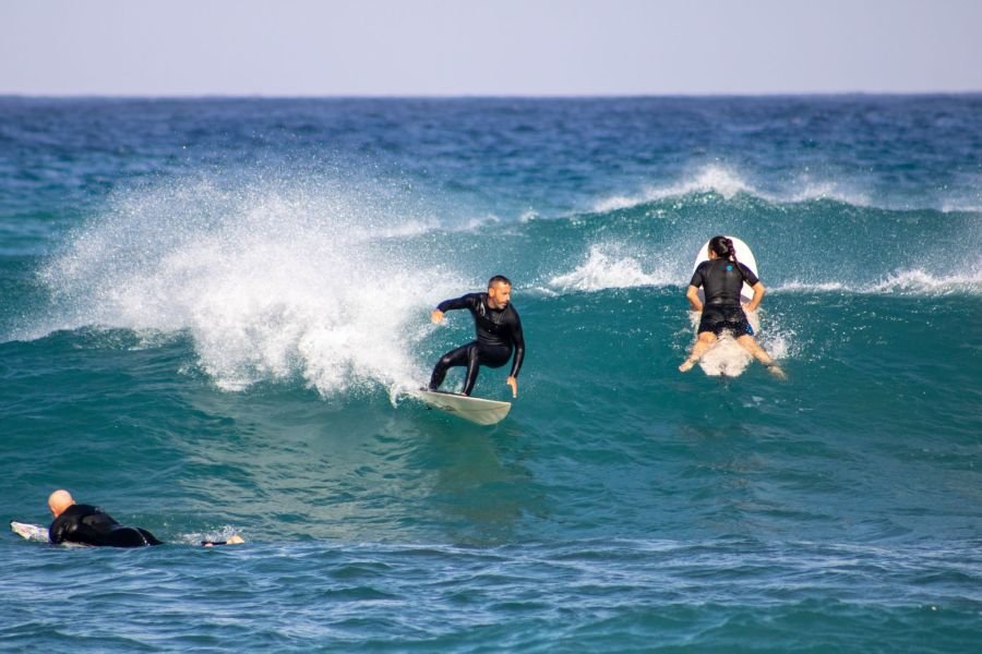 Surfcoach Simone surft eine Welle an seinem Home Spot in Buggerru