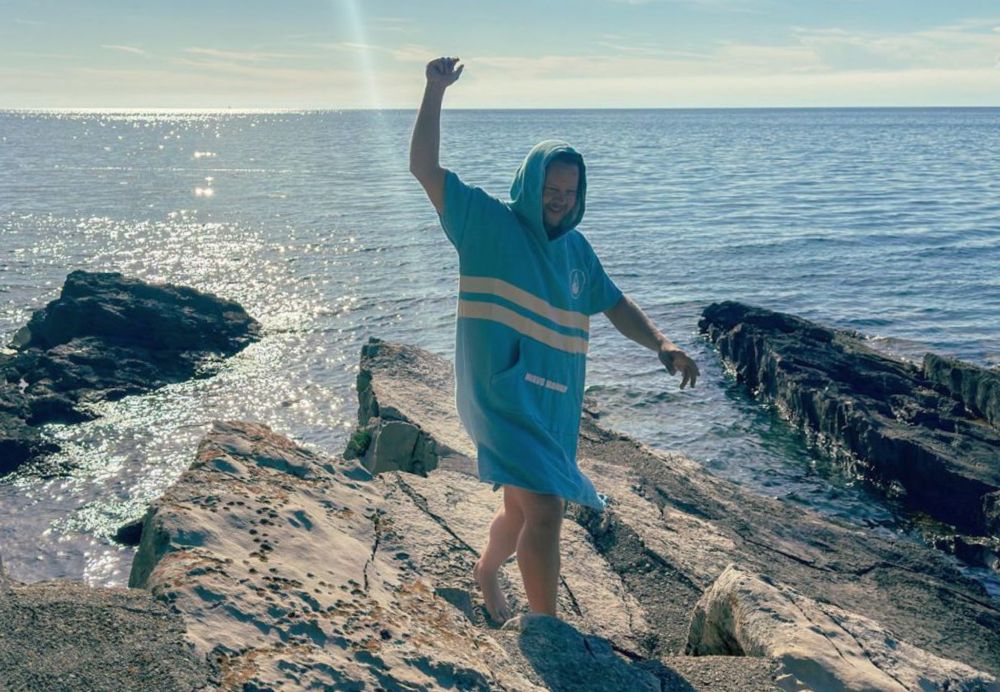 Surfer mit Surf Poncho am Meer